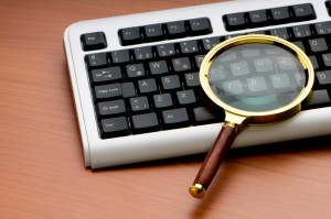 Computer security concept with keyboard and magnifying glass