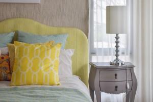Yellow and green and pattern pillows on classic style bed and re